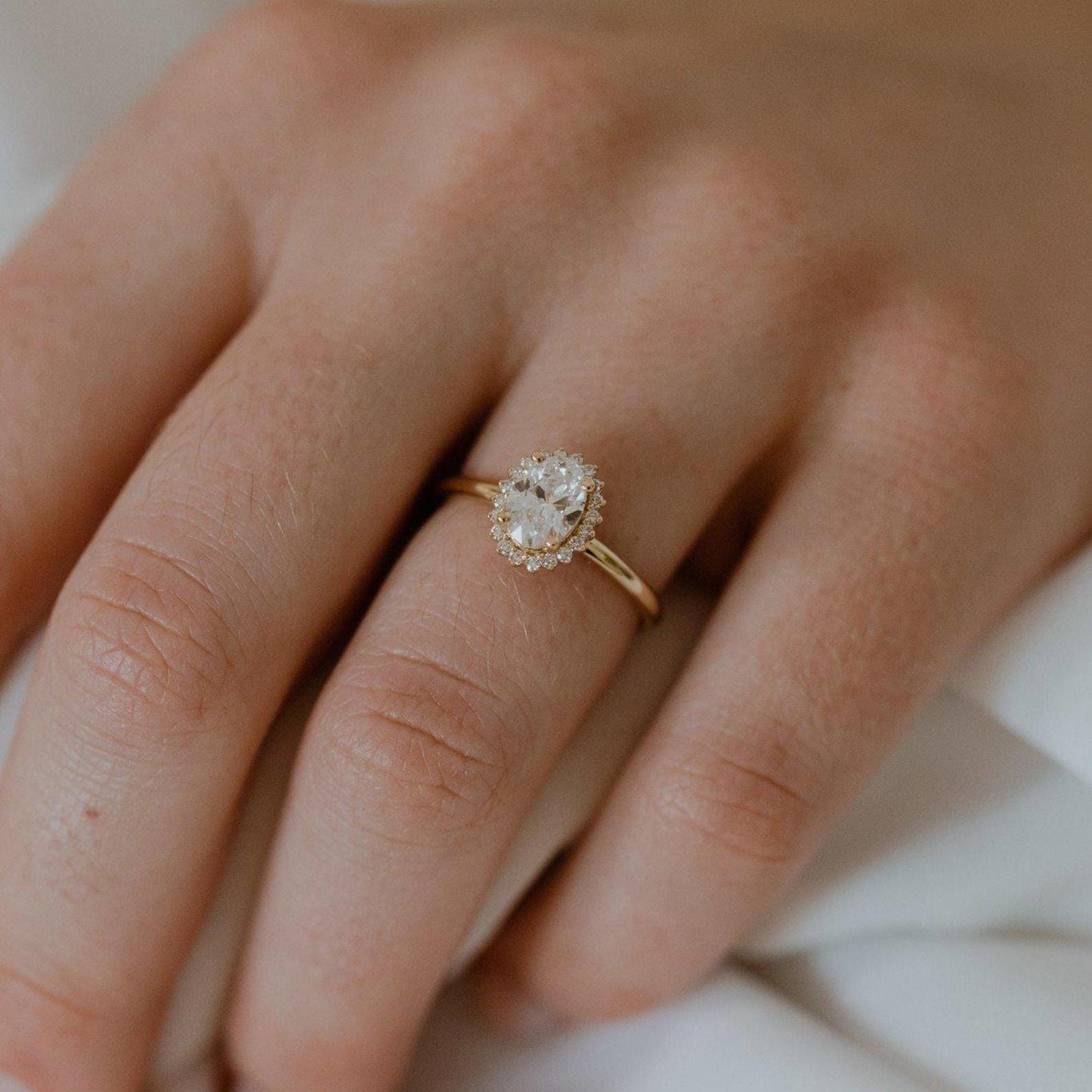 Halo-Style Engagement Ring with Oval Stone and Moissanite Side Stones