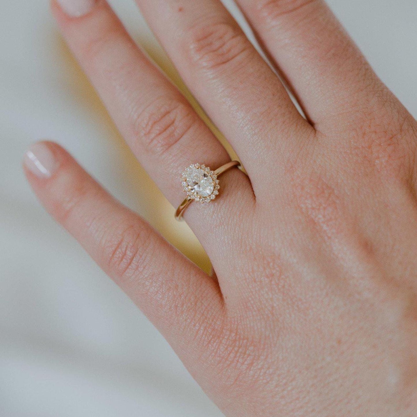 Halo-Style Engagement Ring with Oval Stone and Moissanite Side Stones