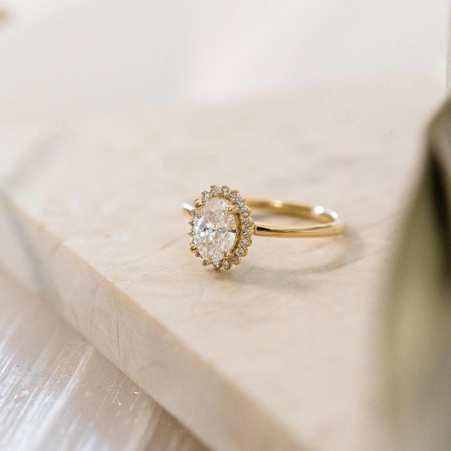 Halo-Style Engagement Ring with Oval Stone and Moissanite Side Stones