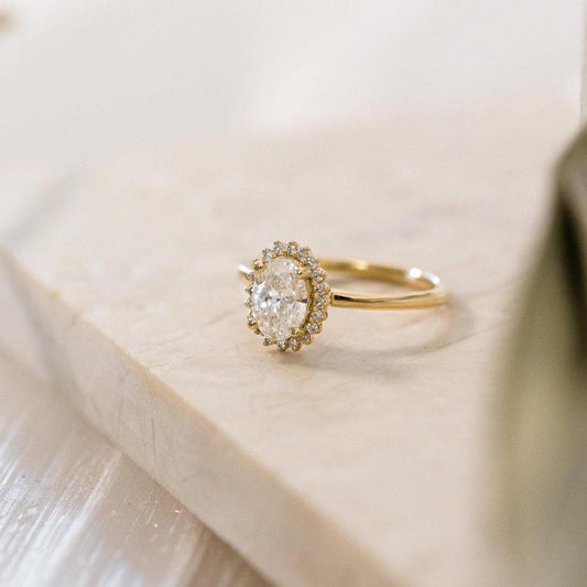 Halo-Style Engagement Ring with Oval Stone and Moissanite Side Stones